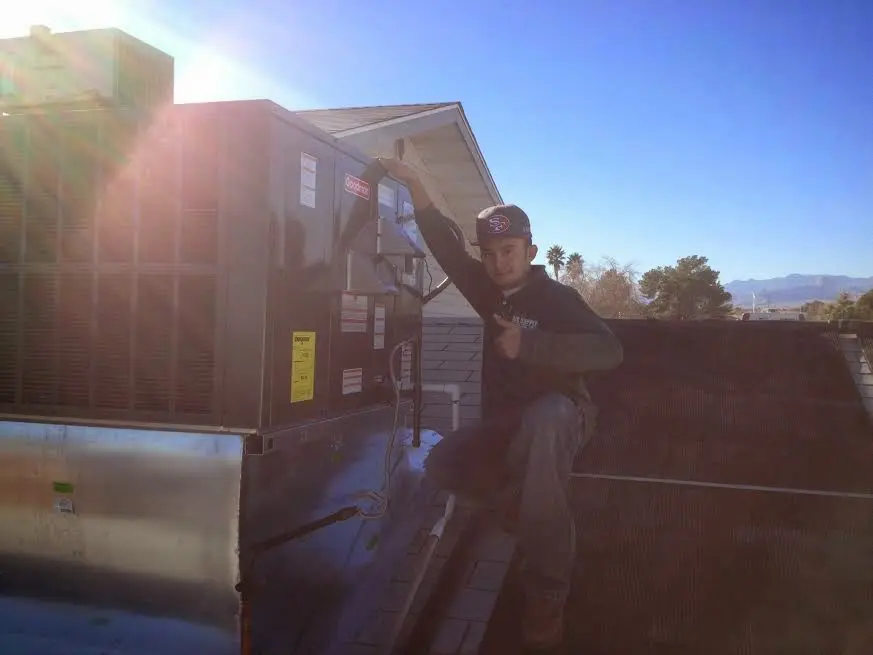 HVAC technician performing Boiler Repair on a rooftop unit in Greene